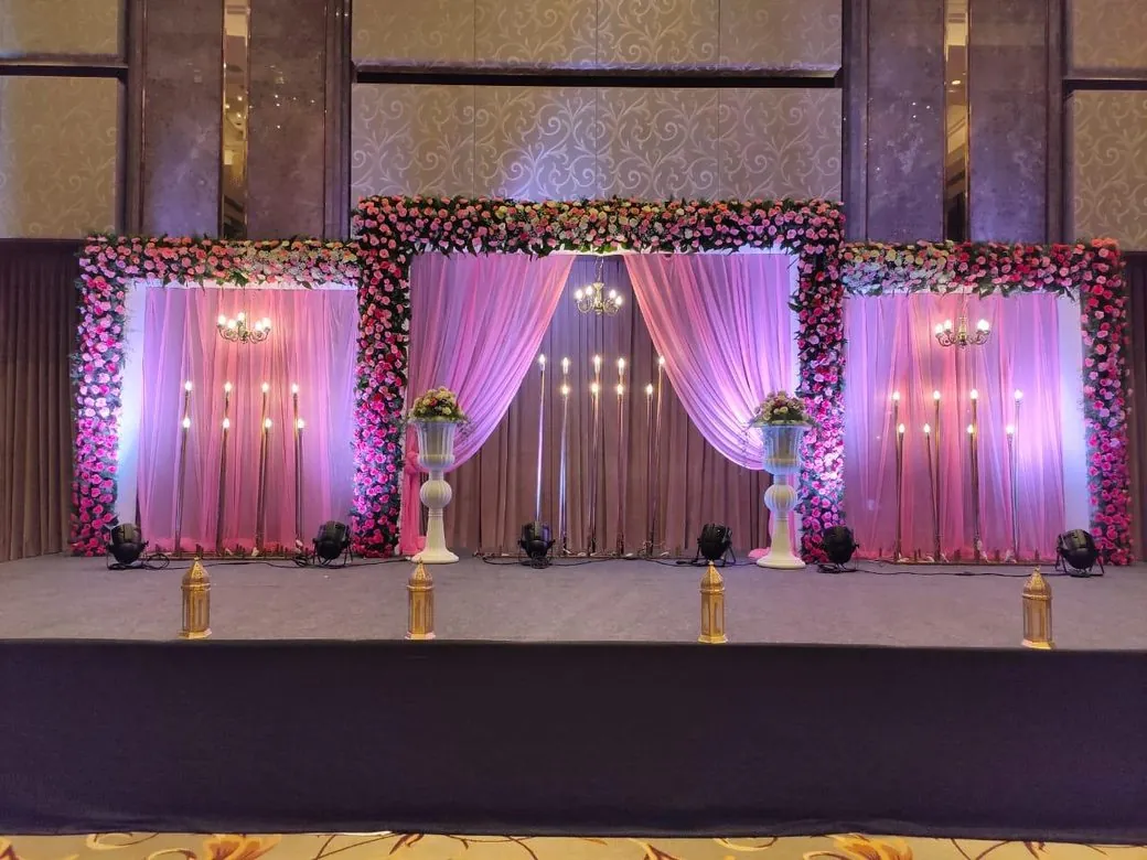 Reception stage with pink floral decoration and drapes