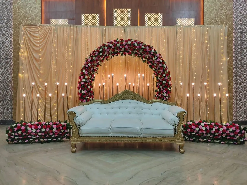 Wedding stage decoration with a floral arch and candles