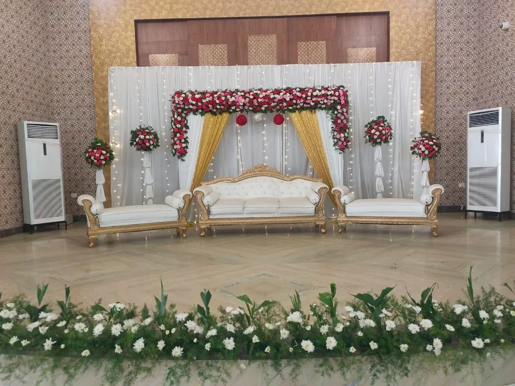 Wedding stage with white drapes and red flowers